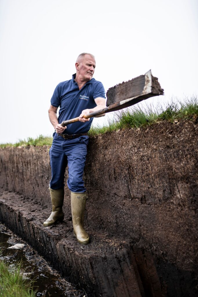 Cutting peat on Islay peatbank for peated single malt scotch whisky